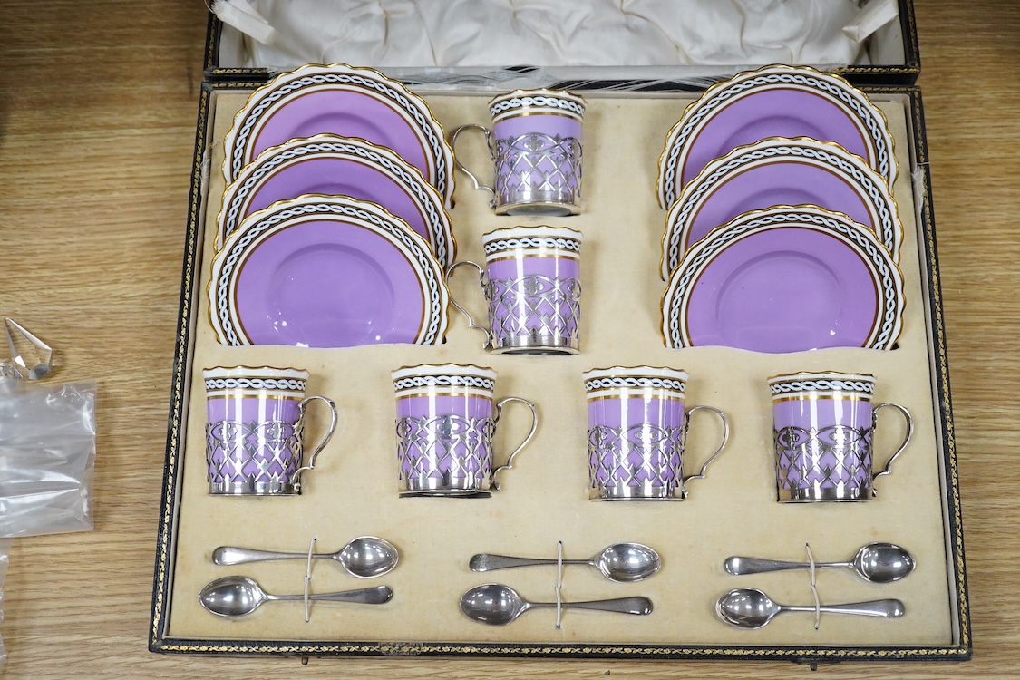 A cased Aynsley coffee set with silver mounted coffee cans and silver teaspoons, William Hutton & Sons, Sheffield, 1924, the leather case 38cm wide